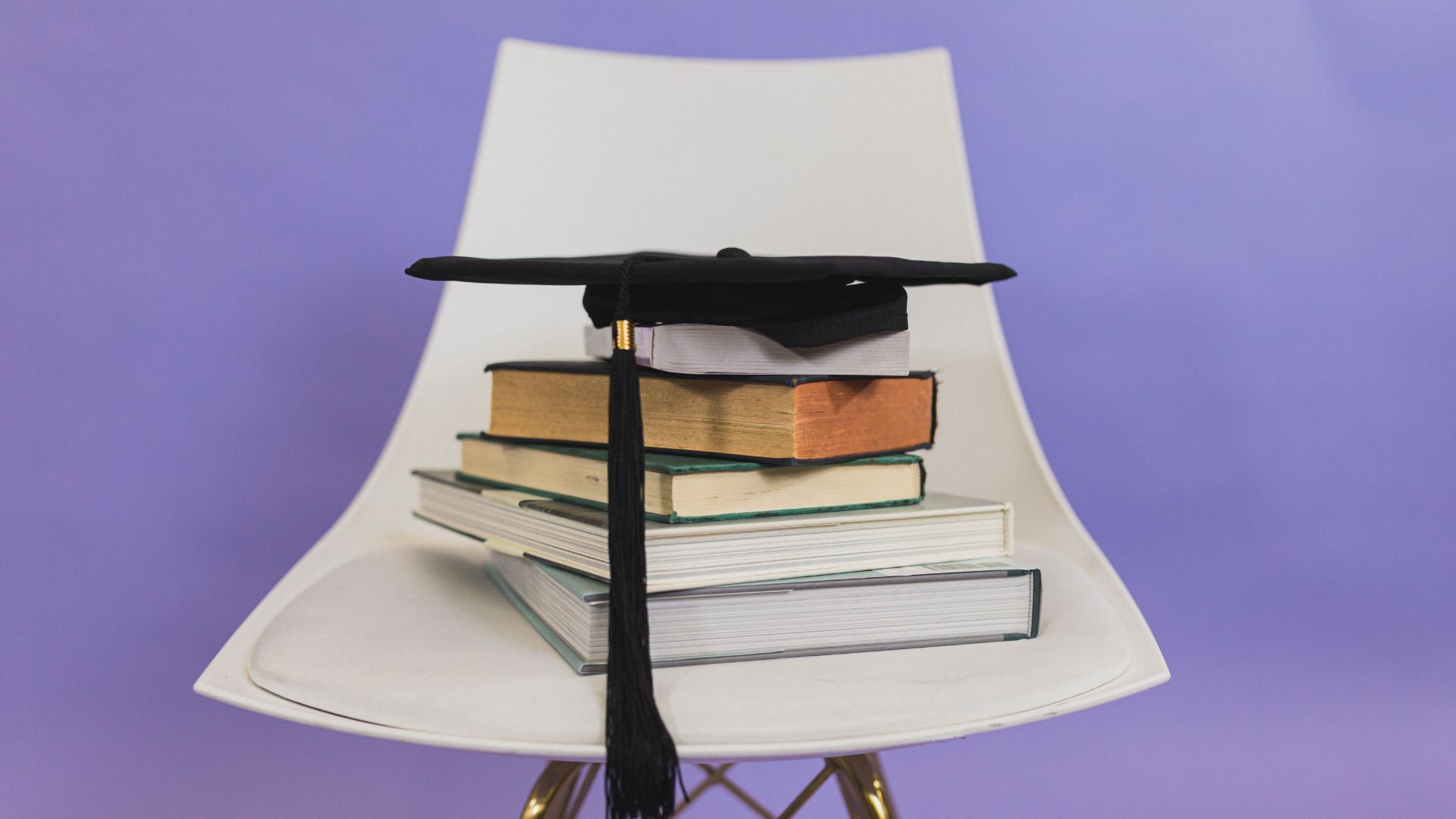Step-By-Step Guide on How to Obtain a College Diploma Replacement 4 graduate cap on top of a stack of school books for college
