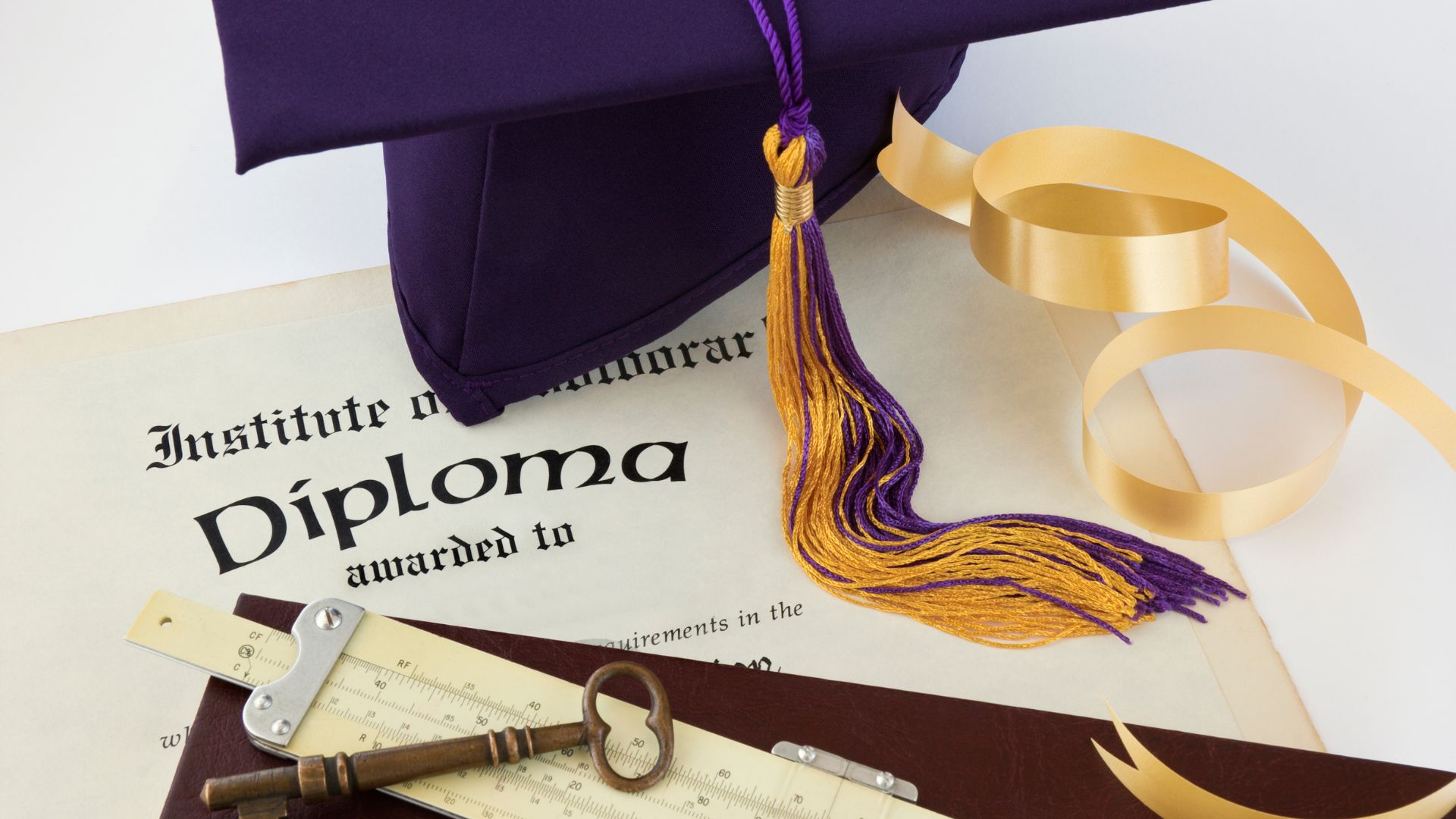 7 Key Traits Of A Diploma Provider That Can Help You Buy Replacement UK Diploma 4 college diploma with brass skeleton key on a table next to a purple and yellow graduate cap and gold ribbon