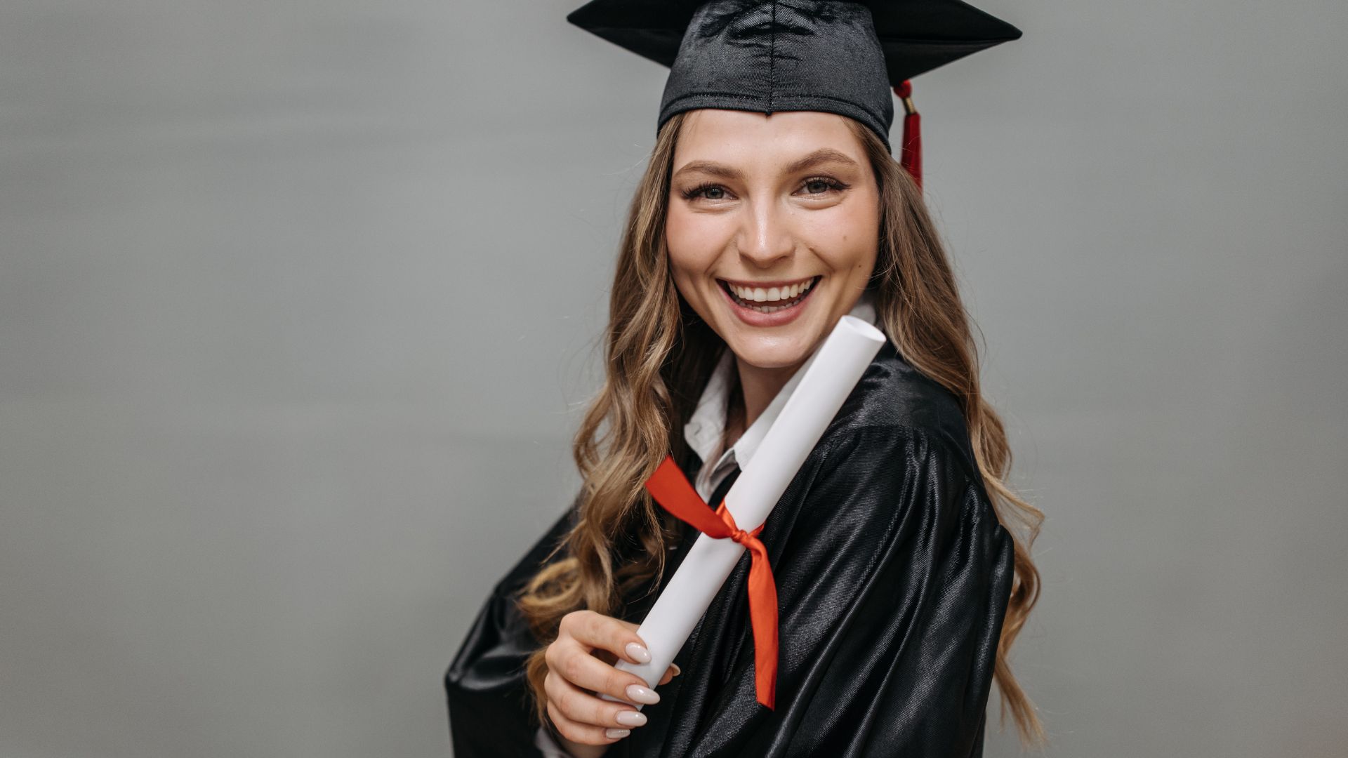 female high school graduate holding diploma