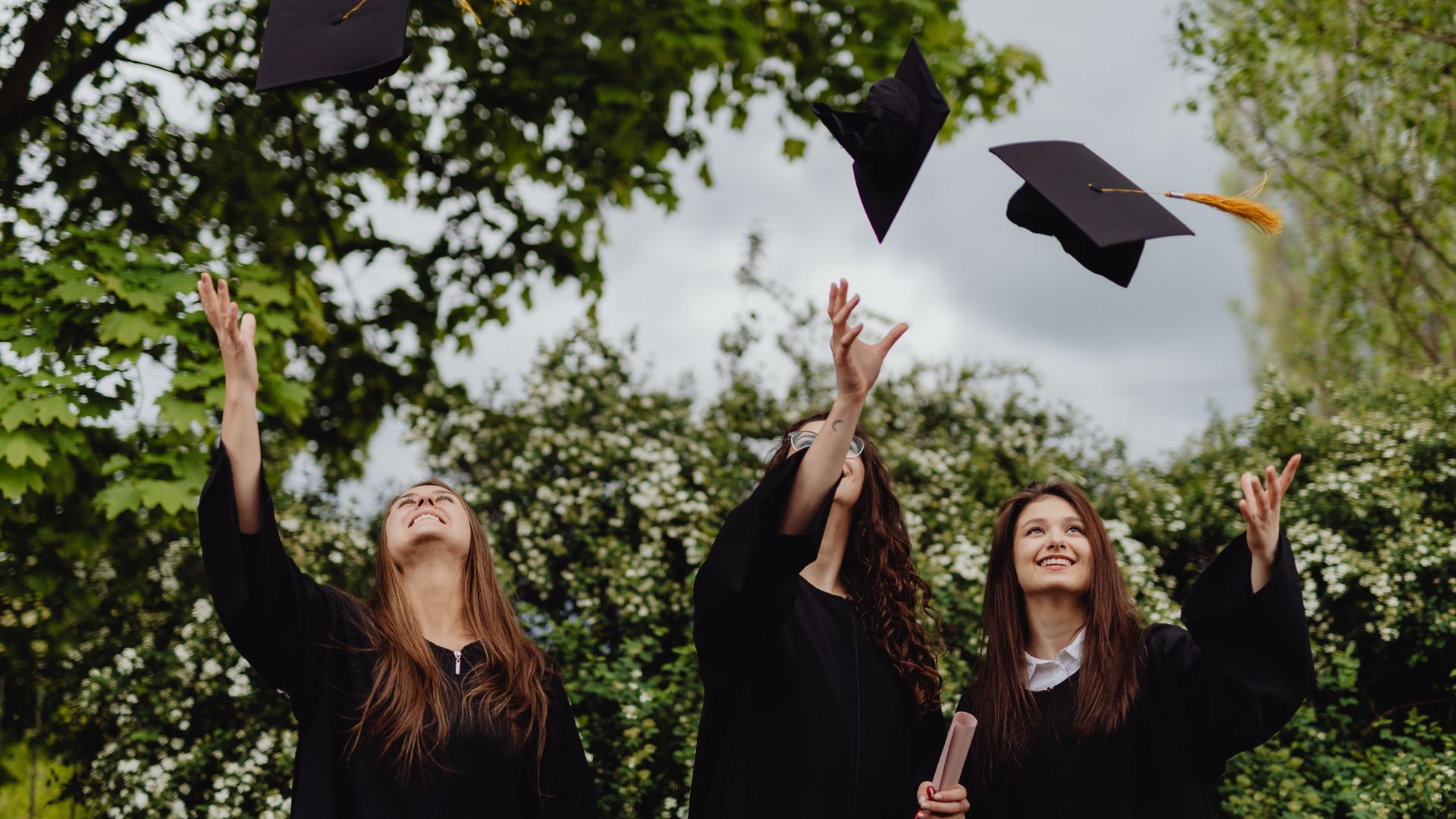 How and Where To Buy Replacement UK Diploma? 4 graduates jumping for job tossing caps into the air celebrating graduation day